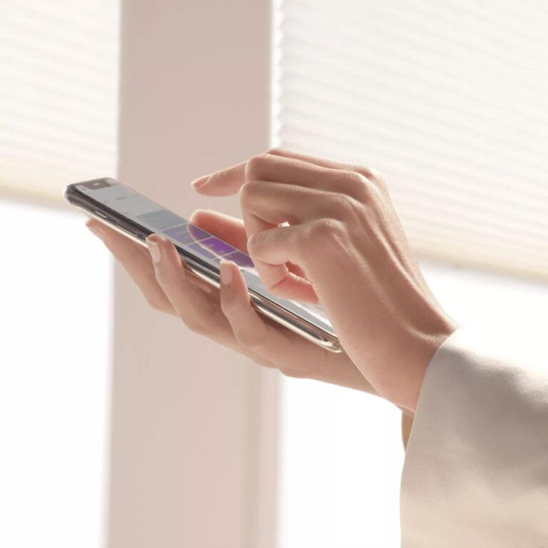 Hand holding a phone with a shade app to adjust motorized shades