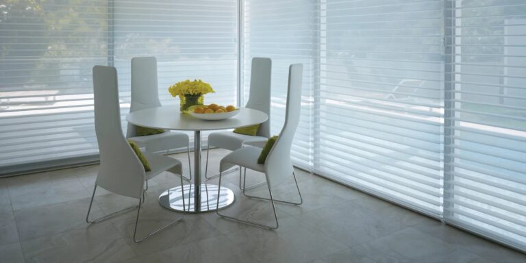 Window shadings on floor-to-ceiling windows around a white round dining table